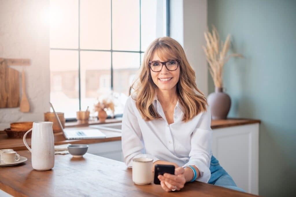Happy,Middle,Aged,Woman,Standing,In,The,Kitchen,At,Home
